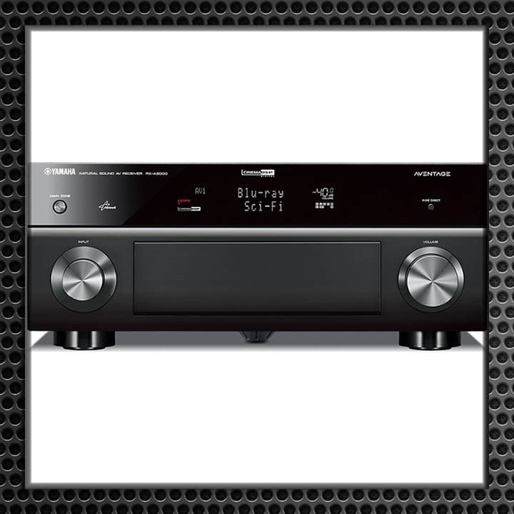 Front view of a high-end home theater audio receiver with digital display, dual control knobs, and various input options.