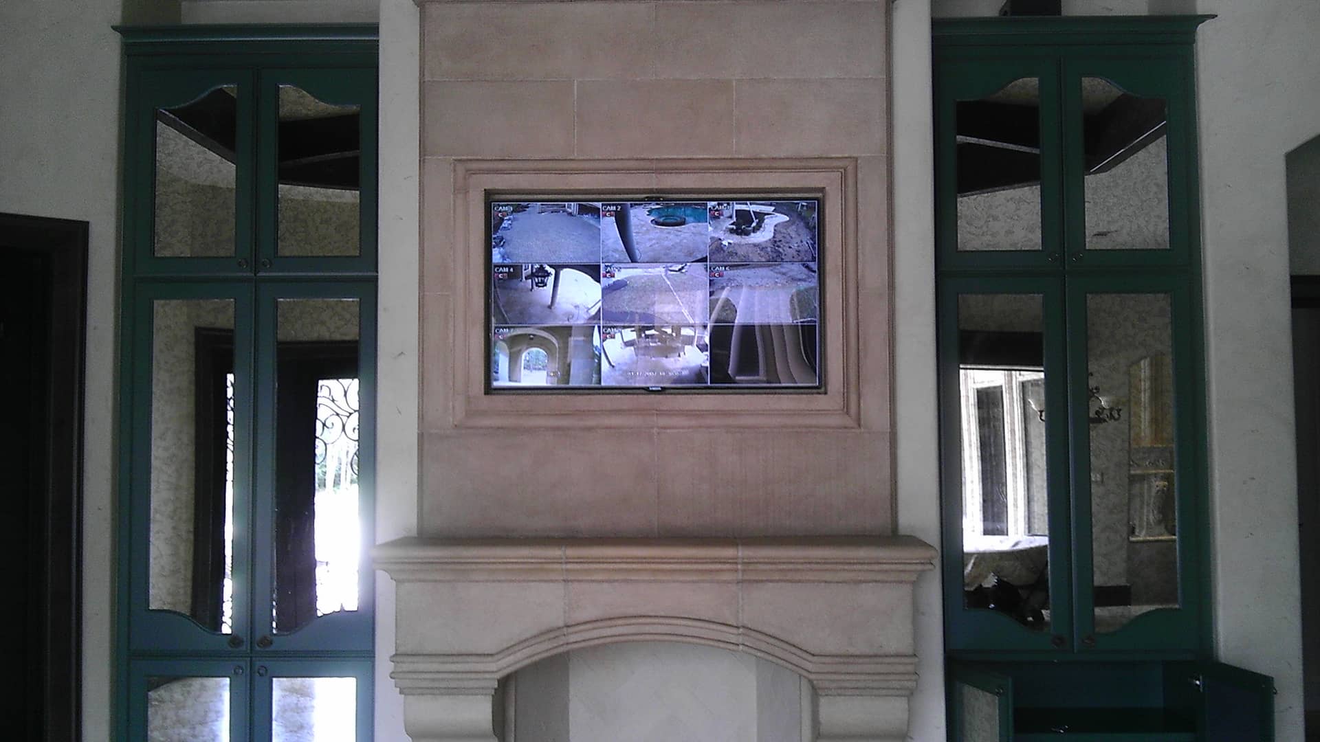 Elegant fireplace mantle featuring a built-in flat-screen TV, surrounded by neutral-toned walls and windows