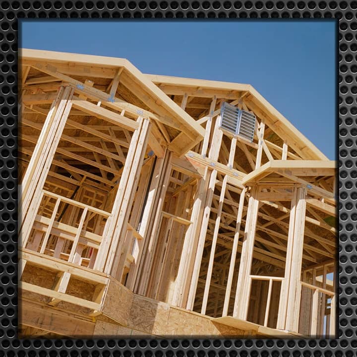 Wooden frame of a new home under construction with a clear blue sky background